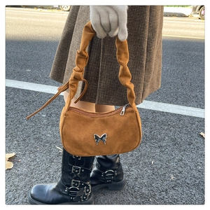 Dettaglio della borsa hobo in pelle scamosciata caramello con manico arricciato