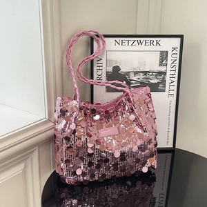 Elegante borsa tote con paillettes rosa e manici intrecciati in ambiente moderno
