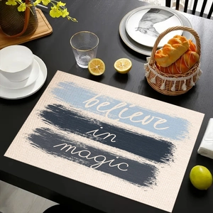 Close-up of linen place mat with 'believe in magic' print and blue stripes on table