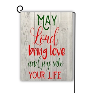 Garden flag detail showing wood texture with red and green text on a black metal stand