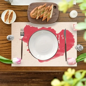 Linen placemat with red watercolor heart and cutlery set on a dark wooden table