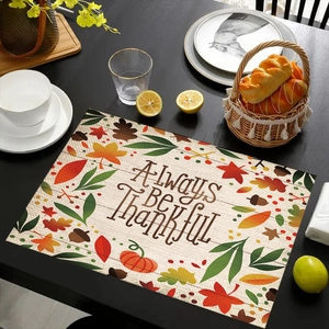 Detalle del mantel individual de lino navideño con estampado 'Always Be Thankful' y motivos