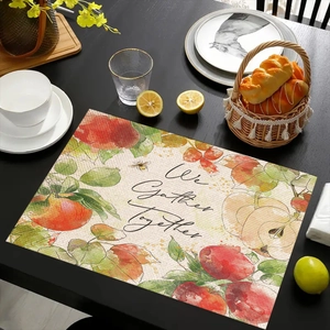 Detalle del mantel individual de lino con diseño We Gather Together y manzanas
