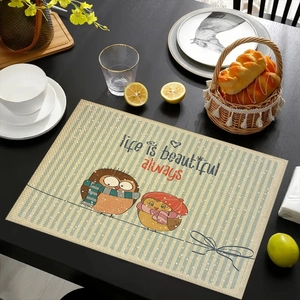 Linen placemat with owls and Life is beautiful text on a black wooden table