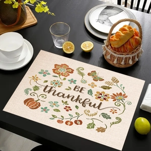 Mantel individual de lino con calabaza 'BE thankful' y flores en mesa de comedor