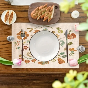 Mantel individual de lino con calabaza y hojas de arce sobre mesa de madera oscura