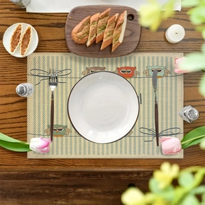 Linen placemat with owl patterns and blue stripes on dark wood table setting