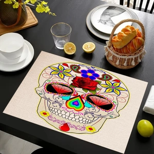 Linen placemat detail showing colorful Day of the Dead sugar skull print on black wood table