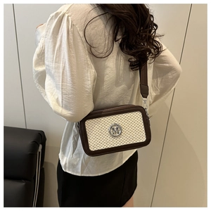 Dettaglio della trama intrecciata e del logo M argentato sulla borsa a tracolla