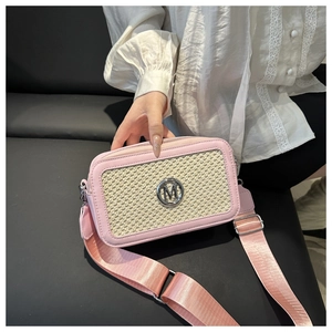 Dettaglio borsa a tracolla intrecciata rosa e beige con logo M in metallo e tracolla larga