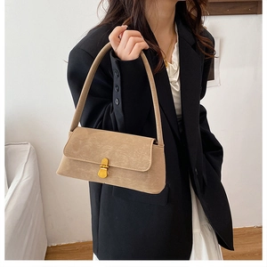 Dettaglio della borsa baguette kaki con trama in pelle vintage e fibbia dorata lucida