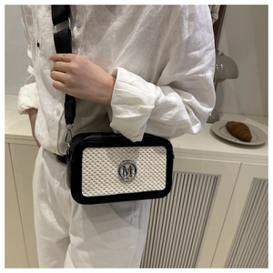 Dettaglio borsa a tracolla a contrasto con logo M e ampia cinghia su modella