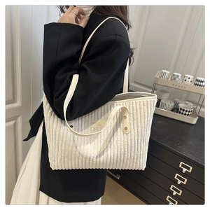 Dettaglio della borsa tote in velluto a coste bianco crema con trama e doppia tracolla