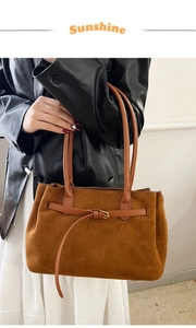 Detail of vintage brown suede tote bag with golden buckle on premium leather strap