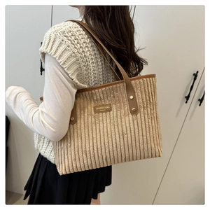 Dettaglio della borsa tote in velluto a coste con manici in pelle e rivetti metallici
