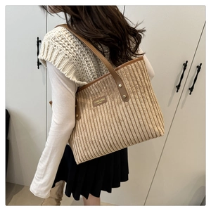 Dettaglio della borsa tote in velluto a coste con texture fine e manici in pelle