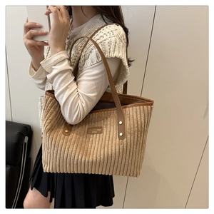 Borsa tote in velluto a coste marrone con finiture in pelle e rivetti dorati su modella