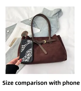Size comparison of dark brown suede tote bag with a smartphone and accessories