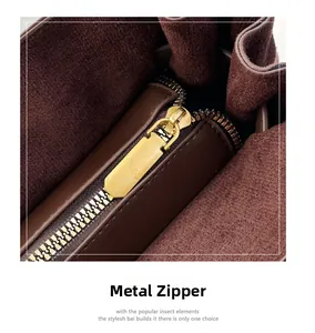 Detailed close-up of premium gold hardware zipper and brown suede lining on the tote bag