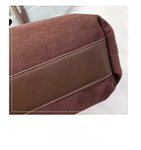 Detailed close-up of premium brown suede texture with durable stitched leather trim