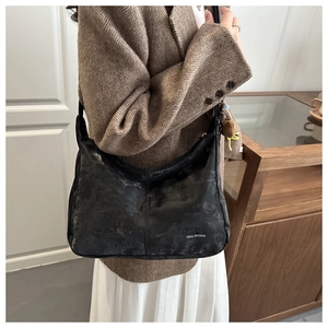 Detail of vintage black hobo bag with Tidal Dryness text on textured material