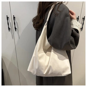 Detail of white large capacity PU leather tote bag worn as a shoulder bag for commuting