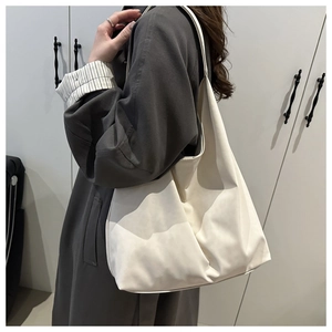 Side view of white minimalist oversized tote bag with soft texture and wide shoulder strap