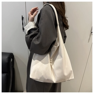 Side view of large cream leather tote bag shown on model for a relaxed fashion look