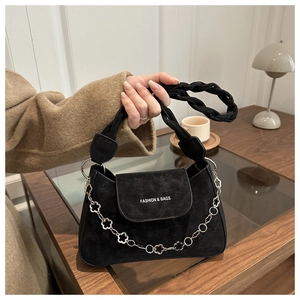 Detail of black frosted suede small square bag with silver floral chain and woven handle