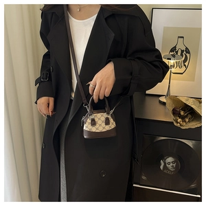Mini shell handbag in brown checkered pattern shown with a black coat for styling