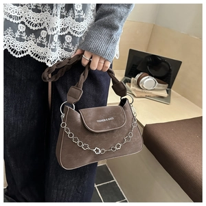 Detail of a brown retro woven bag with a floral silver chain and fashion text