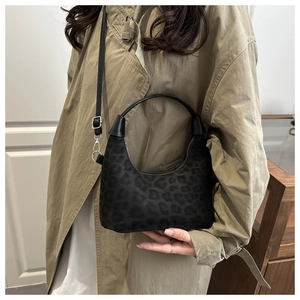 Dettaglio della borsa hobo vintage scamosciata leopardata con manico in pelle e cerniera