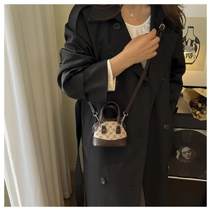 Detailed view of mini shell bag with monogram canvas and brown leather strap on model