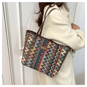 Detail of colorful geometric jacquard tote bag with leather handles and metal rivets