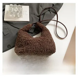Dettaglio ravvicinato della borsa a tracolla marrone in peluche con cinturino in pelle