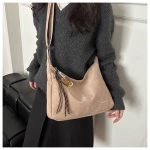 Détail du sac cabas en daim beige avec franges et pendentif en cœur pour le quotidien