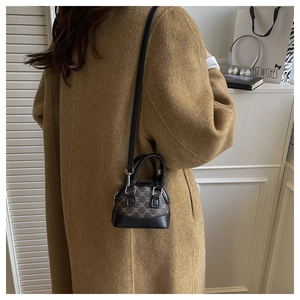 Detailed side view of a mini shell crossbody bag with brown pattern and leather strap