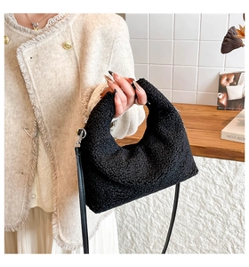 Dettaglio borsa a mezzaluna nera in peluche con sottile tracolla in pelle e texture morbida