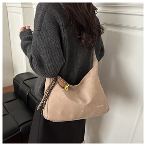 Detail of beige hobo bag with floral scarf and cute plush charm on a fashion model
