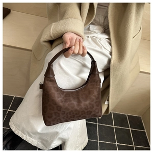 Dettaglio borsa hobo scamosciata leopardata con cerniera argento e manico curvo