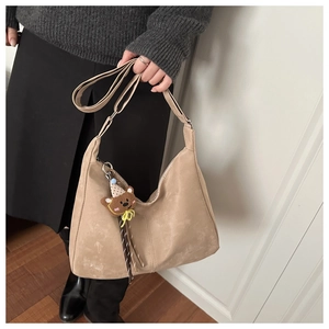 Détail du sac hobo beige avec pendentif ours mignon et bandoulière réglable