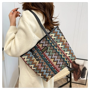 Detail der Ethno-Canvas-Tasche mit schwarzen Lederriemen und goldfarbenen Metallnieten