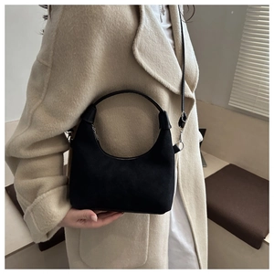 Dettaglio della borsa hobo in pelle scamosciata nera con zip e tracolla regolabile
