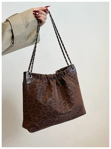 Detail of leopard print tote bag with metal chain straps and Creative Cat logo print