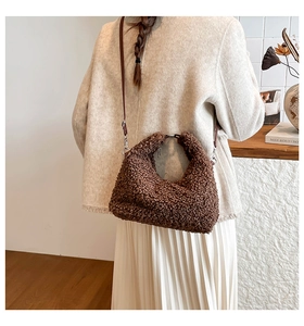 Dettaglio della borsa a tracolla in peluche marrone con texture soffice e cinturino