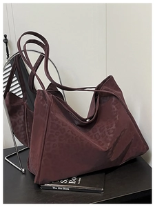 Close-up of wine red leopard print tote bag showing smooth fabric texture and side structure