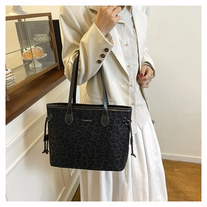 Détail d'un grand sac cabas léopard porté avec un tailleur élégant pour femme