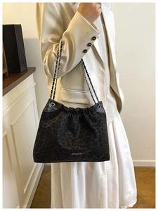 Detail of leopard print tote bag with drawstring design and gold logo branding