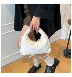 Dettaglio borsa a tracolla bianca in tessuto peluche con design a mezzaluna morbida