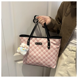 Dettaglio della borsa tote a quadri rosa con trama impermeabile e ciondolo a cane